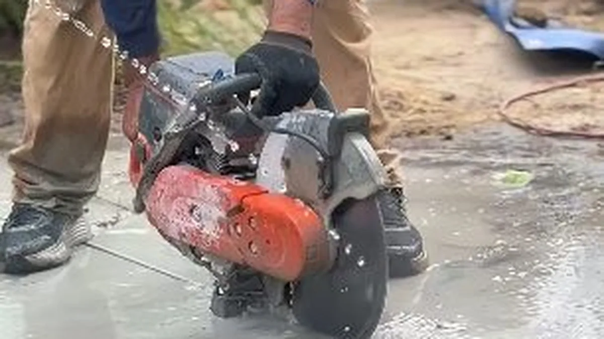 Plumber operating a hydro-jetting hose to clear a sewer line