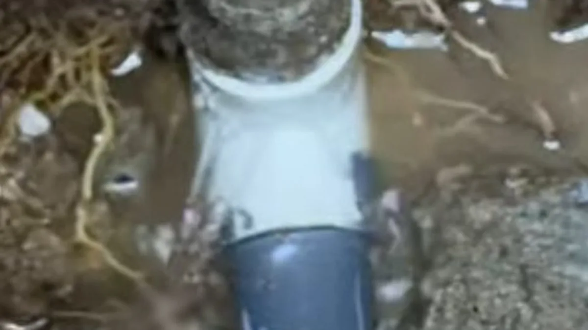 Plumber working at a sewer line cleanout during a repair