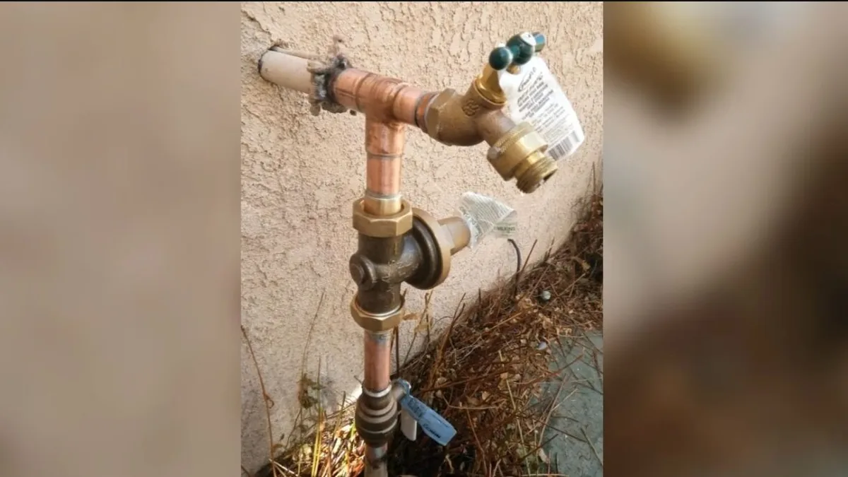 Plumber servicing the tank connections on a residential water heater